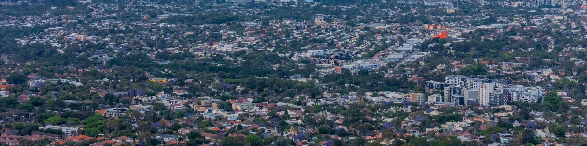 Panorama Sunset aerial drone view of western Sydney Suburbs of Canterbury Burwood Ashfield Marrickville Campsie with Houses roads and parks in Sydney New South Wales NSW Australia
