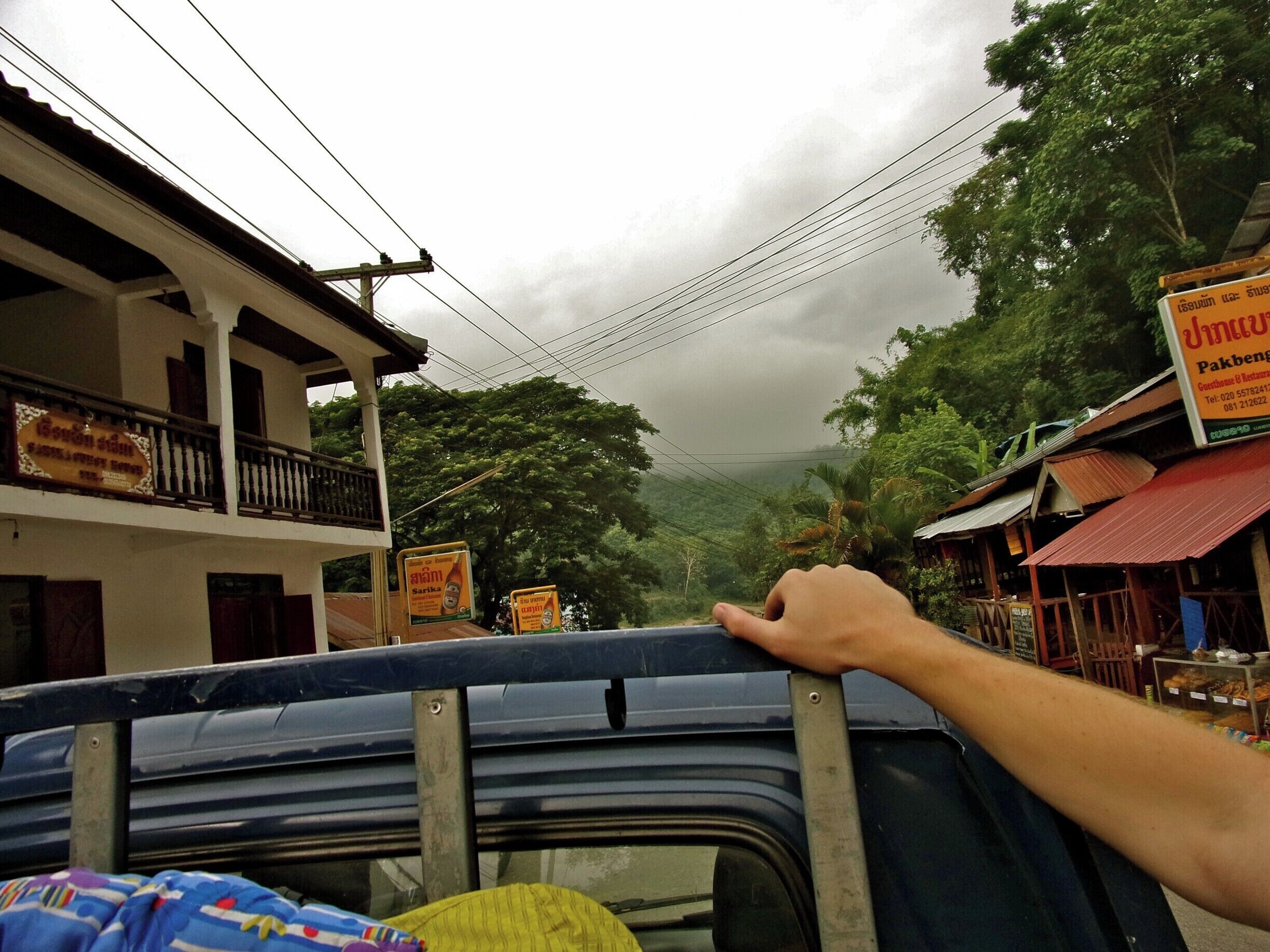A vehicle parked on a street with buildings and trees in the background.