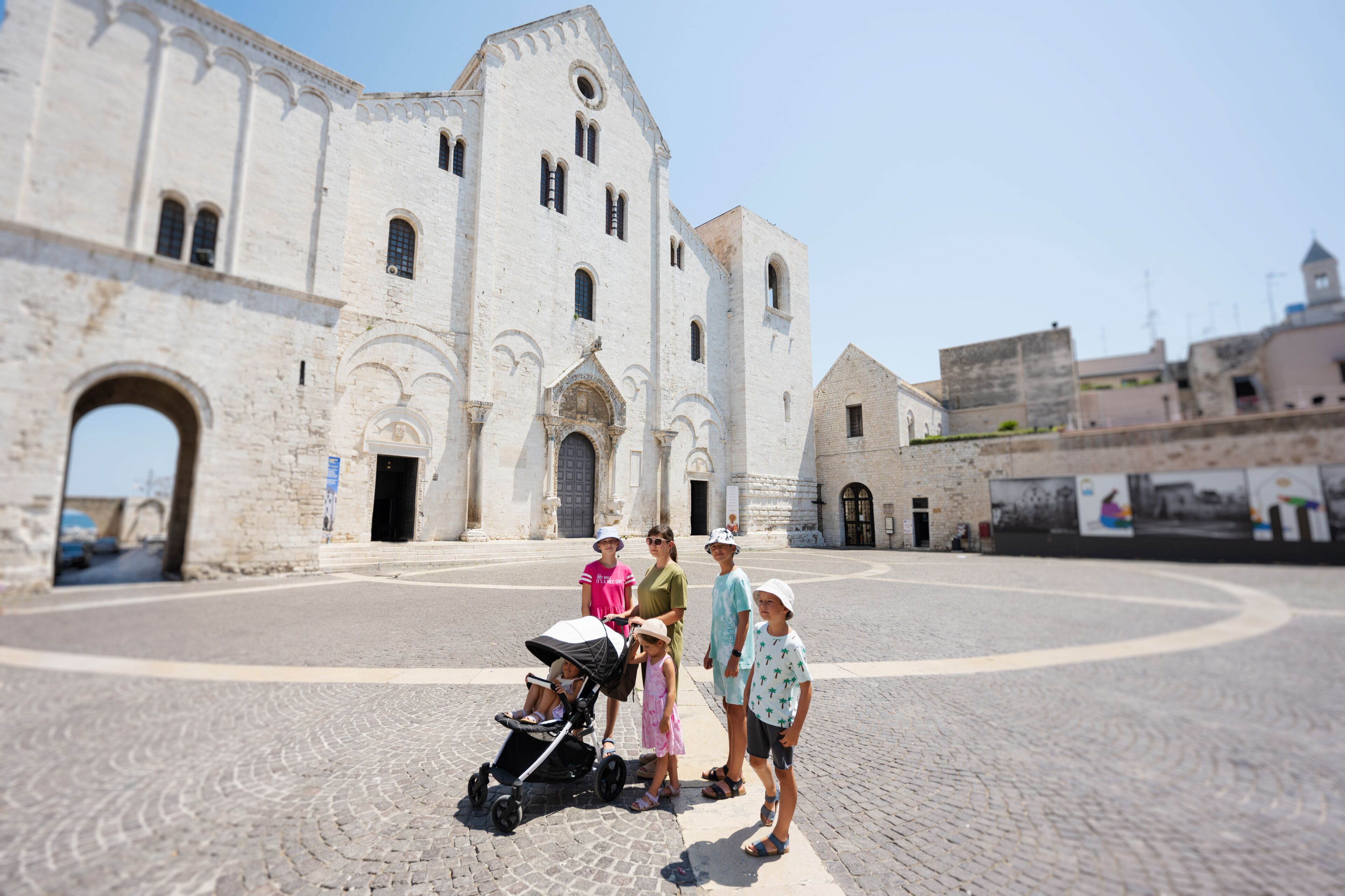 Family of tourists against Basilica of Saint Nicholas in Bari, catholic church, Puglia, South Italy.