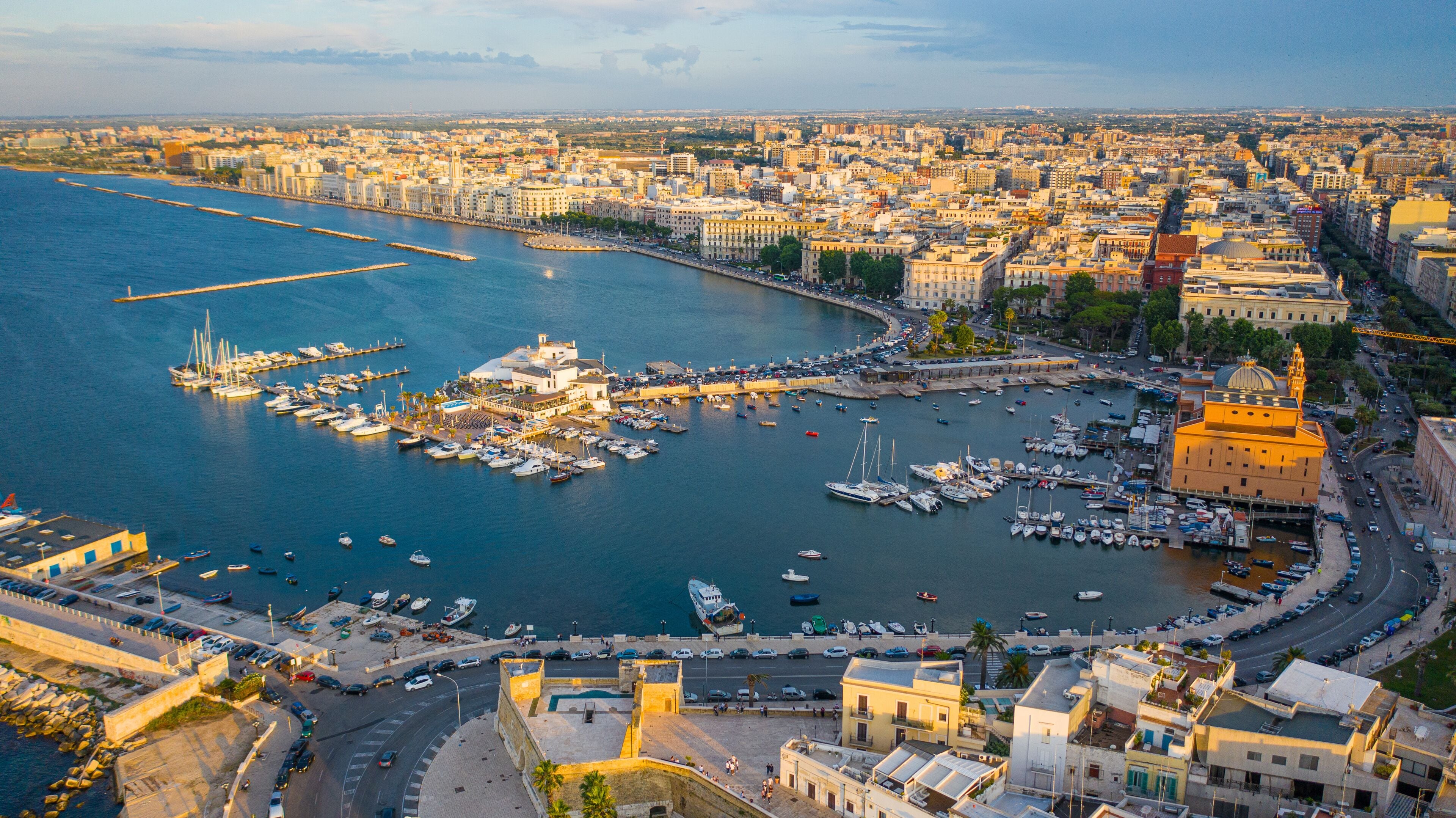 Beautiful panoramic aerial view photo from flying drone at sunset to Bari Apulia City port boats and yachts Sea Coastline, Teatro Margherita, and Bari city skyline. Bari ,Apulia, Italy (Series)