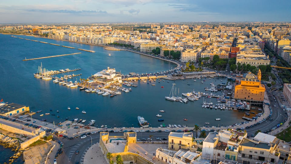Beautiful panoramic aerial view photo from flying drone at sunset to Bari Apulia City port boats and yachts Sea Coastline, Teatro Margherita, and Bari city skyline. Bari ,Apulia, Italy (Series)