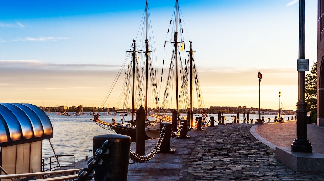 First light catches the bollards and heavy chains by the moored tall ships in Boston Harbor