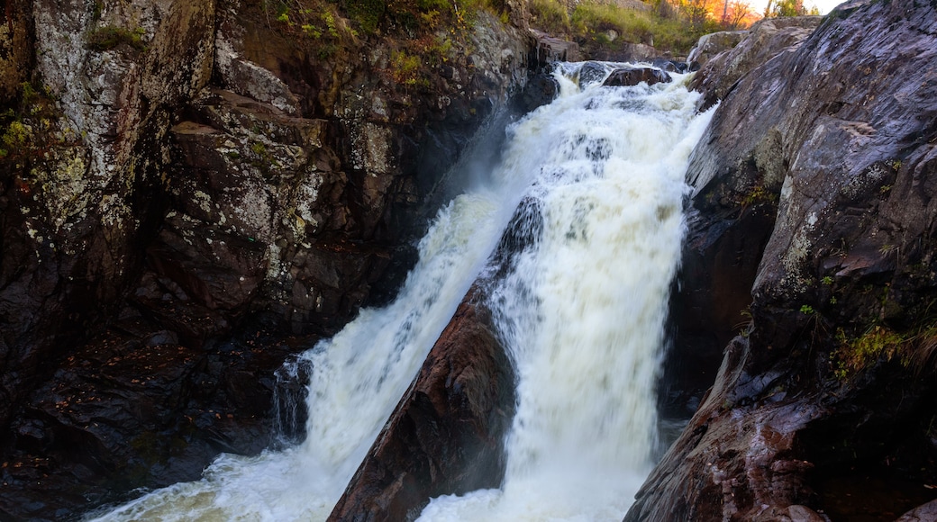 A powerful waterfall cascading over rocky terrain with moss-covered stones.