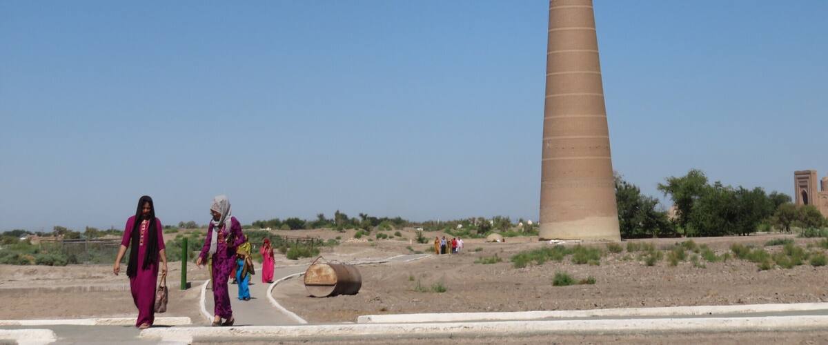 A tall, slender tower in a desert landscape with a clear blue sky.