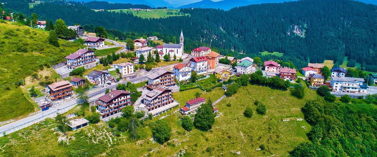 A mountainous village with colorful buildings, a church, and a road.