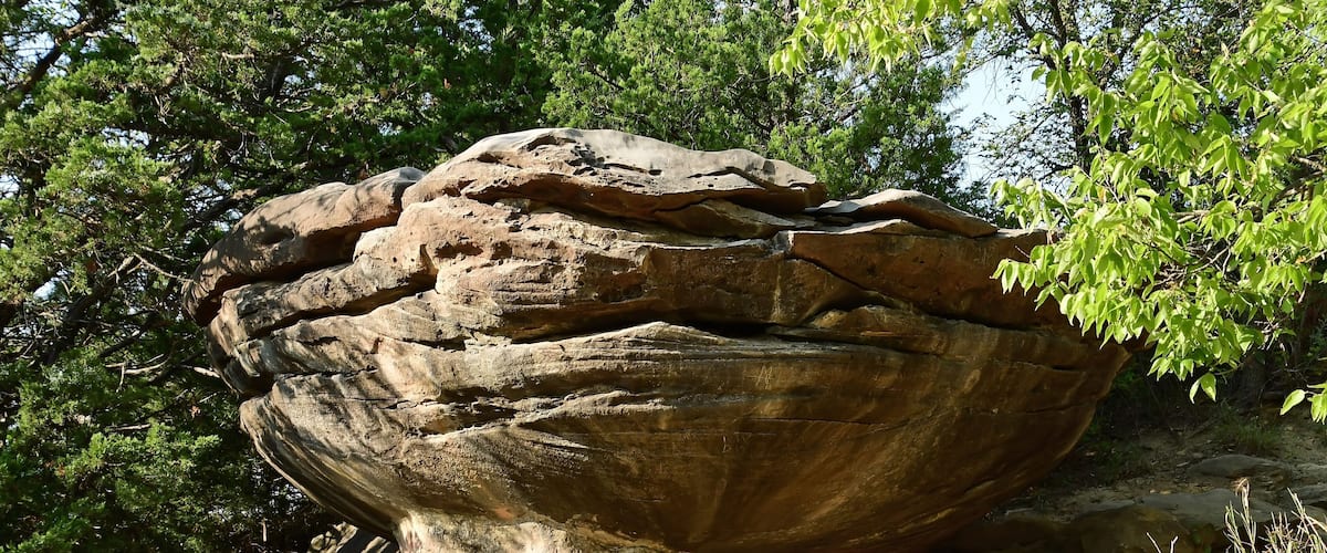 A large rock formation surrounded by trees.
