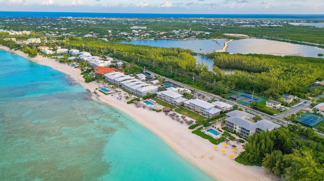 7 Seven Mile Beach Grand Cayman Cayman Islands pristine turquoise blue water white sand Caribbean sea Atlantic ocean hotels beachfront villas condos sunrise sunny day sky and clouds lush greenery