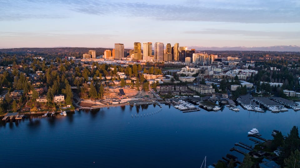 A cityscape with a marina and a mountain range in the background.