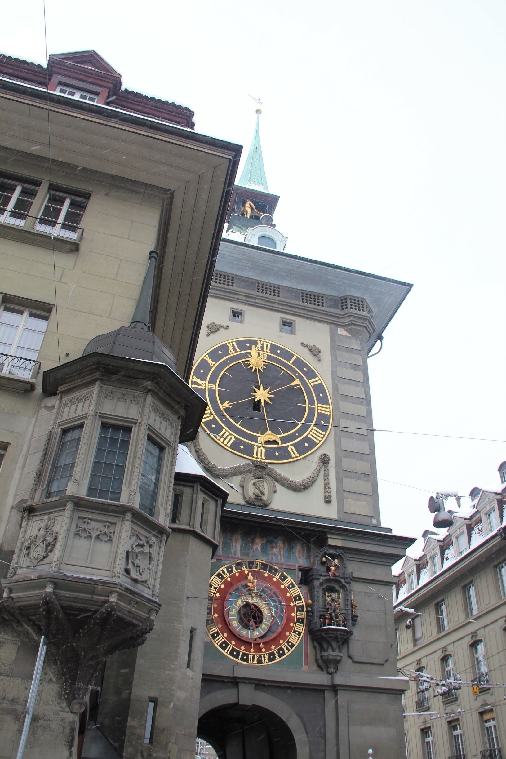 A large ornate clock tower with a spire, a smaller clock below, and a decorative archway.