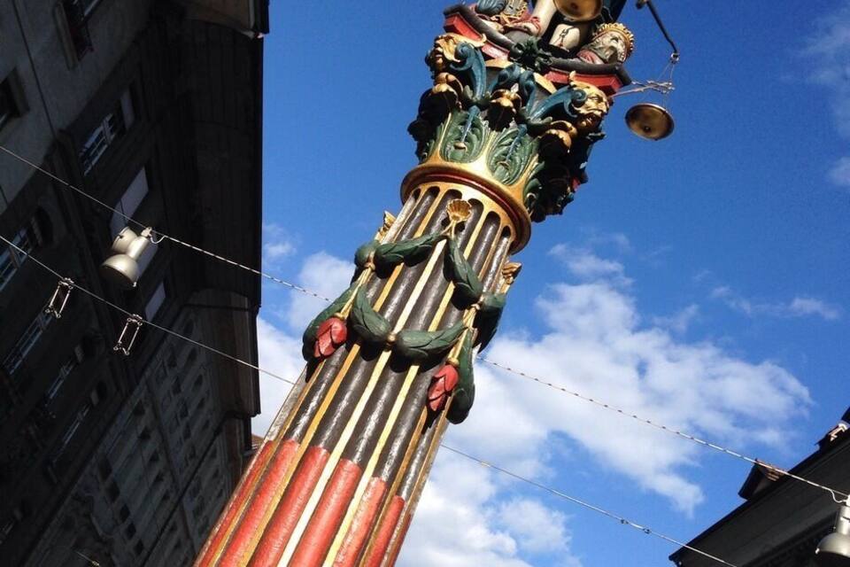 Patsas seisoo pylvään päällä, ja taustalla on kirkkaan sininen taivas.