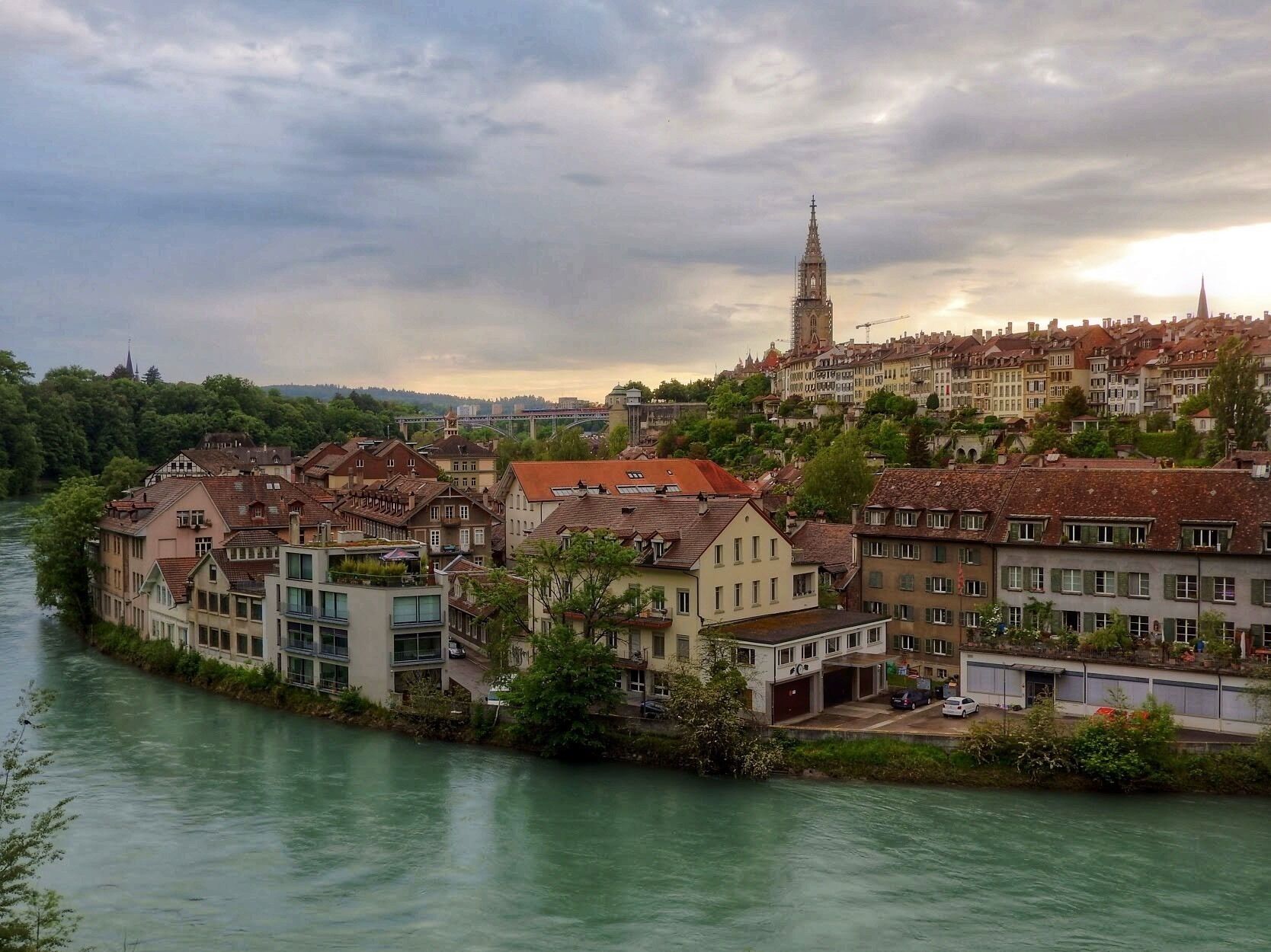 A riverside town with historic buildings and a prominent church tower.