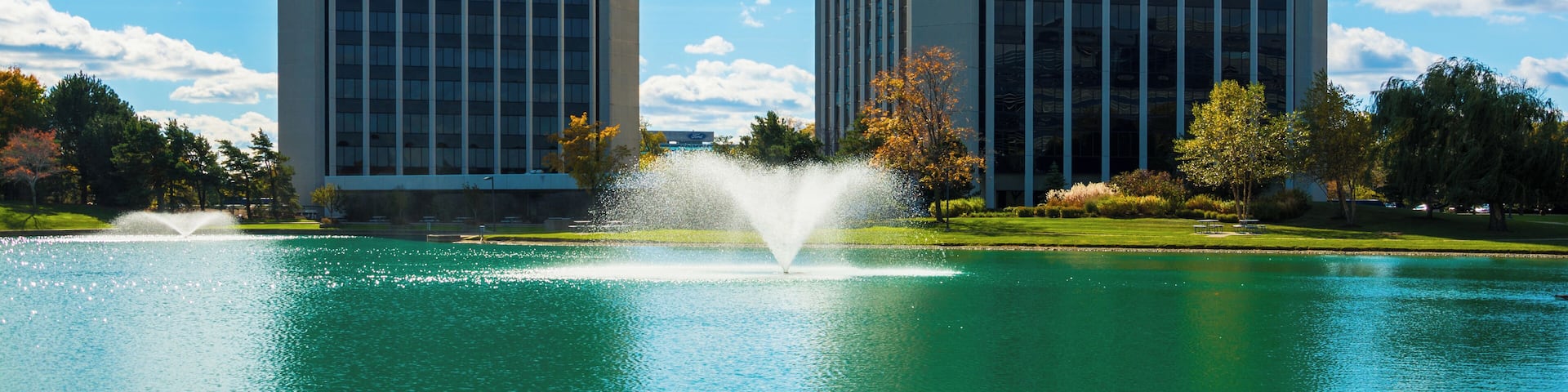 Park Lane Towers, a twin tower office complex in Dearborn, Michigan, with a pond with water fountains in the foreground. Dearborn is a part of the Metro Detroit area.