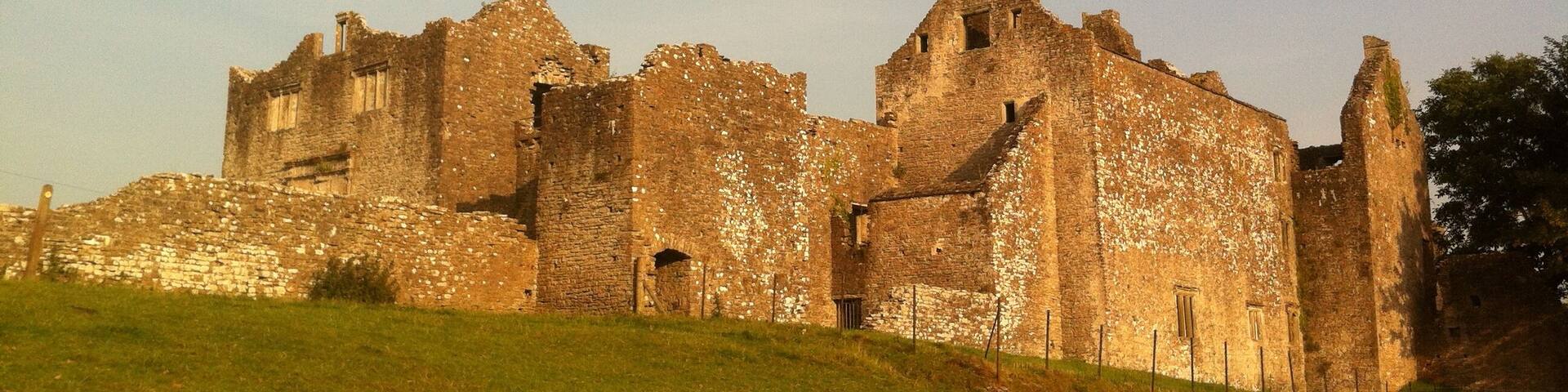 An ancient stone castle on a grassy hill.