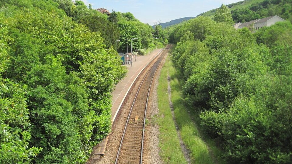 Dinas Rhondda railway station, Rhondda Cynon Taf. Opened in 1886 by the Taff Vale Railway on the line from Cardiff to Treherbert, this station replaced a previous one called Pandy. View south east towards Pandy and Cardiff. The platforms at Pandy started from just beyond the end of the current platform. As built, Dinas Rhondda had a further two tracks and a platform to the right of the line shown. Pandy only had two tracks and it is likely the enforced shift 200m west to the current location was because there was no room to widen the track at Pandy station. All a little ironic, as when this image was taken, there was only one!
