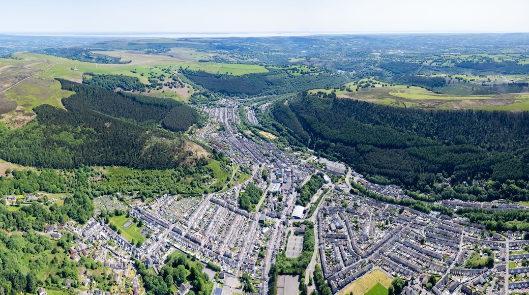 Une vue aérienne d’une ville nichée dans une vallée, entourée de collines et de forêts.
