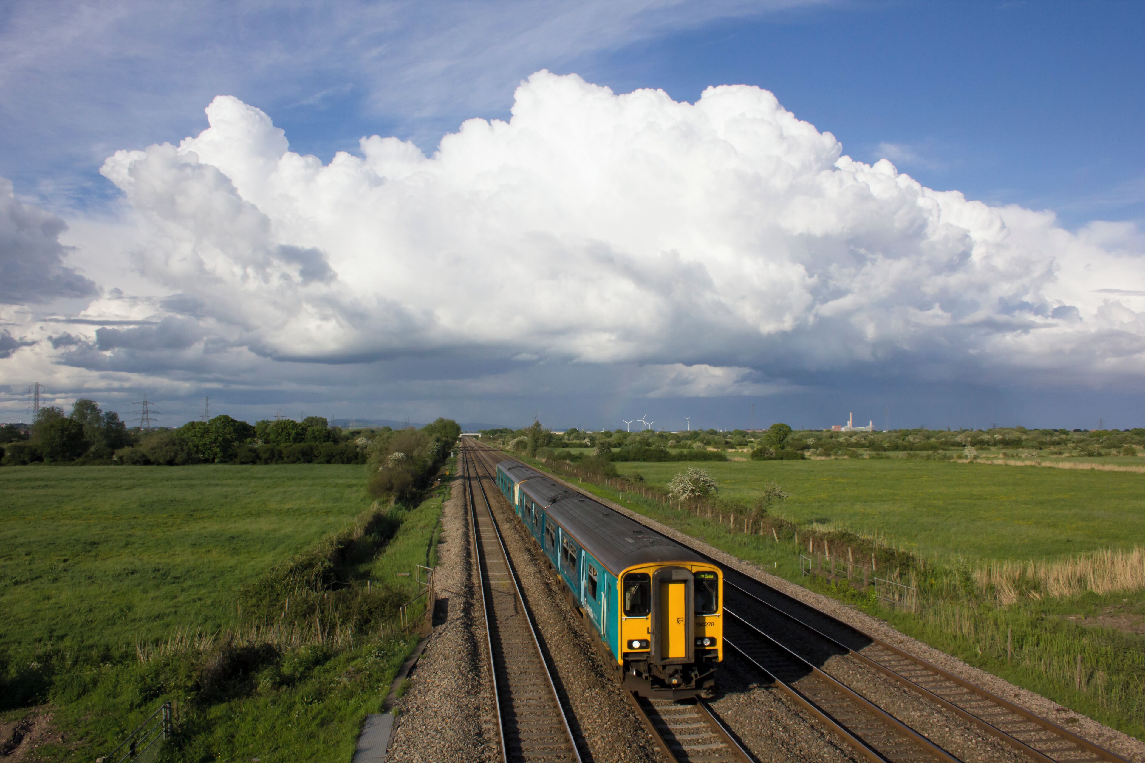 Arriva Trains Wales Class 150 DMU 150278 leads a class mate on the 1V18 1530 Manchester Piccadilly to Cardiff Central service on Sunday 22nd May 2016. The train is seen passing Coedkernew, between Newport and Cardiff. As the sky behind the train suggests, it was a day of sunshine and showers.