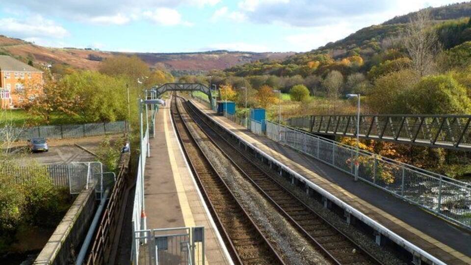 Ystrad Rhondda railway station. The station is on the Rhondda Line, between Llwynypia station (about a mile ahead) and Ton Pentre station, a little less than a mile behind the camera. The twin tracks through the station merge into one track beyond the footbridge ahead. Of interest to trivia fans - Ystrad Rhondda is alphabetically the last railway station in the UK.