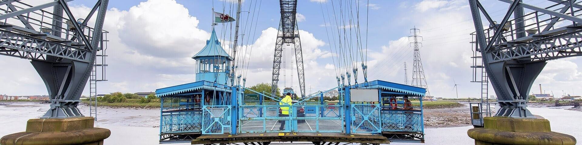 The coolest "bridge" I have ever "driven" across! Drive aboard and take flight over the River Usk in this 110 year old engineering marvel. Only six of these historic bridges remain in operation, and the Newport Bridge is the longest with a 196m span (645ft).
A modern highway bridge passes nearby, so these days the bridge operates as a novelty. Show up on either side, and the operator will come pick you up! You can also climb the steps and walk across the 54m (180ft) high catwalk.