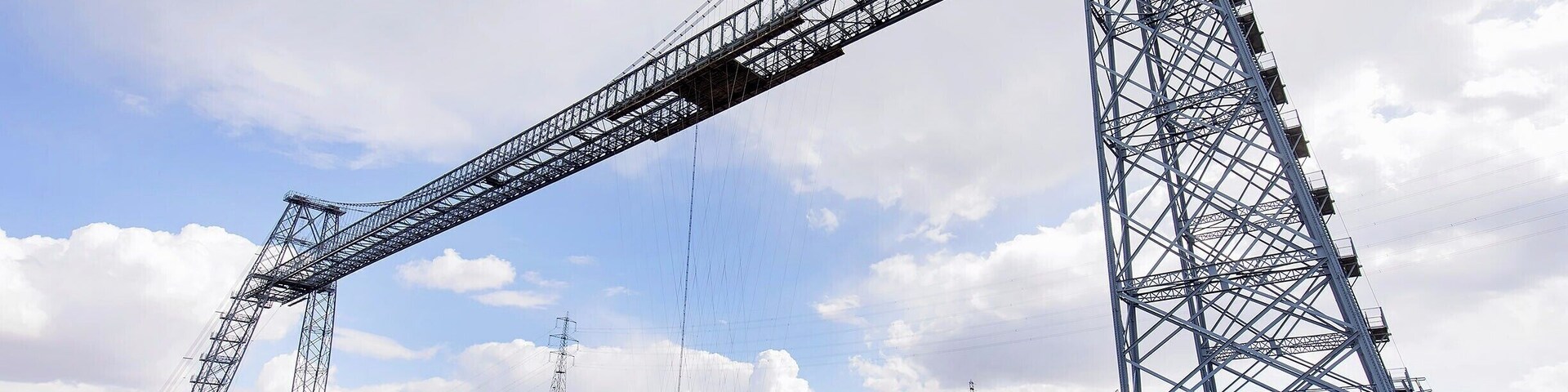 The coolest "bridge" I have ever "driven" across! Drive aboard and take flight over the River Usk in this 110 year old engineering marvel. Only six of these historic bridges remain in operation, and the Newport Bridge is the longest with a 196m span (645ft).
A modern highway bridge passes nearby, so these days the bridge operates as a novelty. Show up on either side, and the operator will come pick you up! You can also climb the steps and walk across the 54m (180ft) high catwalk.