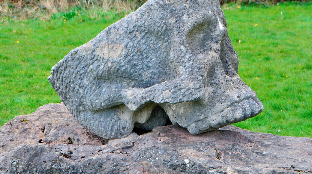 Sculptor Robert Kennedy.
Six separate small upright works set on stone bases; two boxing gloves, two dolls, cherub and a skull. Information from Festival Park: 'The works were carved away from site during 1991. They are made to operate as conventional garden ornamentation, within a constructed garden. The boxing gloves are there to depict some of their associated aspects, such as maleness and competition. The dolls depict something of how an image is idealised for mass consumption, becoming a distortion of the human figure. Both the gloves and the dolls can be seen as gendering devices through role play. The cherub and skull are life and death charms. Each of these suggests ways in which we adopt roles in society. What we really are is never as clear cut as what these images suggest.'
Borderline was supported by Garden Festival Wales and Chapter Arts Centre. 'The sculptor, Robert Kennedy, felt that the Garden Festival was a huge, themed social event in itself. He wanted to create a themed garden within it, something social, commenting to some extent on the diversity of culture within real society.'
A number of sculptures were commissioned for the Garden Festival of Wales in 1991/2 and some works remain on site.