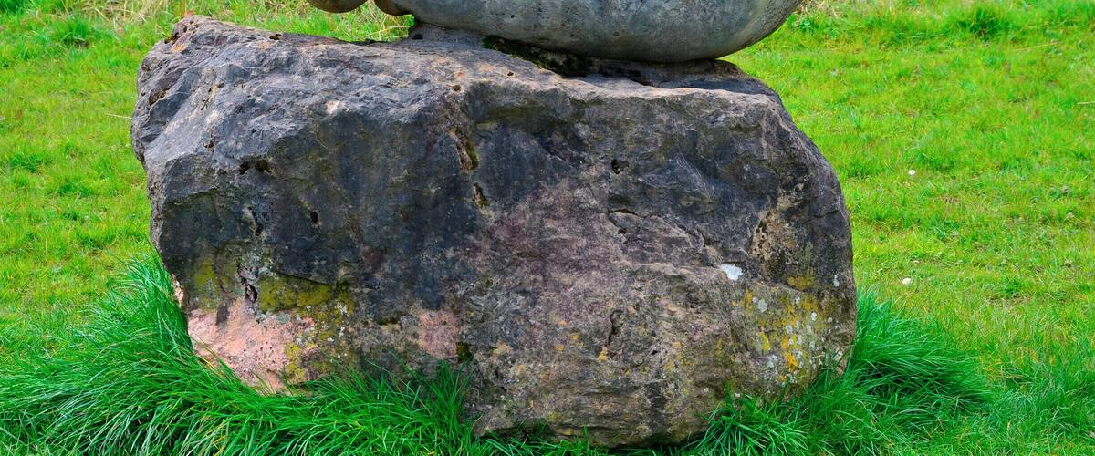 A large rock with a carved snake figure on top.