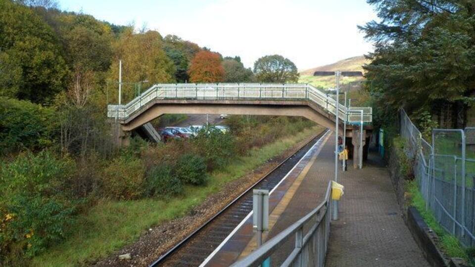 Llwynypia railway station. Viewed down the access ramp from the A4058. Llwynypia station is on the Rhondda Line, between Tonypandy station to the south and Ystrad Rhondda station to the north. The footbridge leads to the station's car park (capacity 12 vehicles).