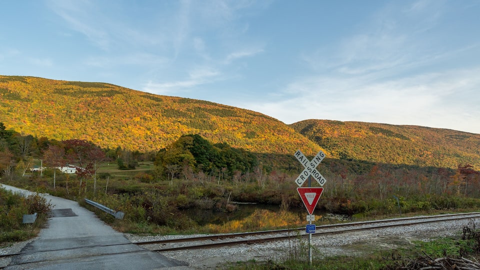 A railroad crossing with a yield sign and a 'Railroad Crossing' sign.
