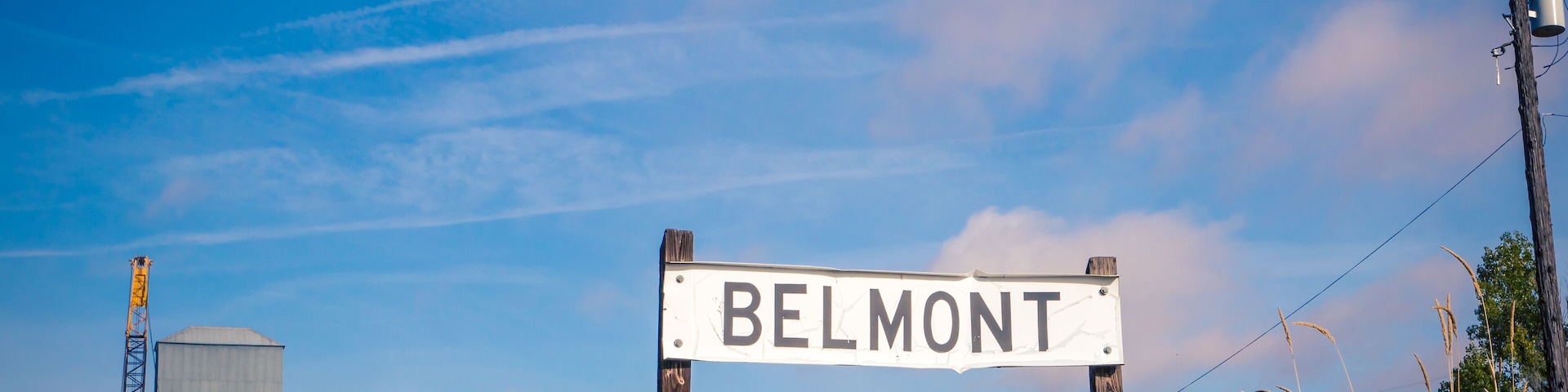 A sign reading "BELMONT" with a construction crane and power lines in the background.
