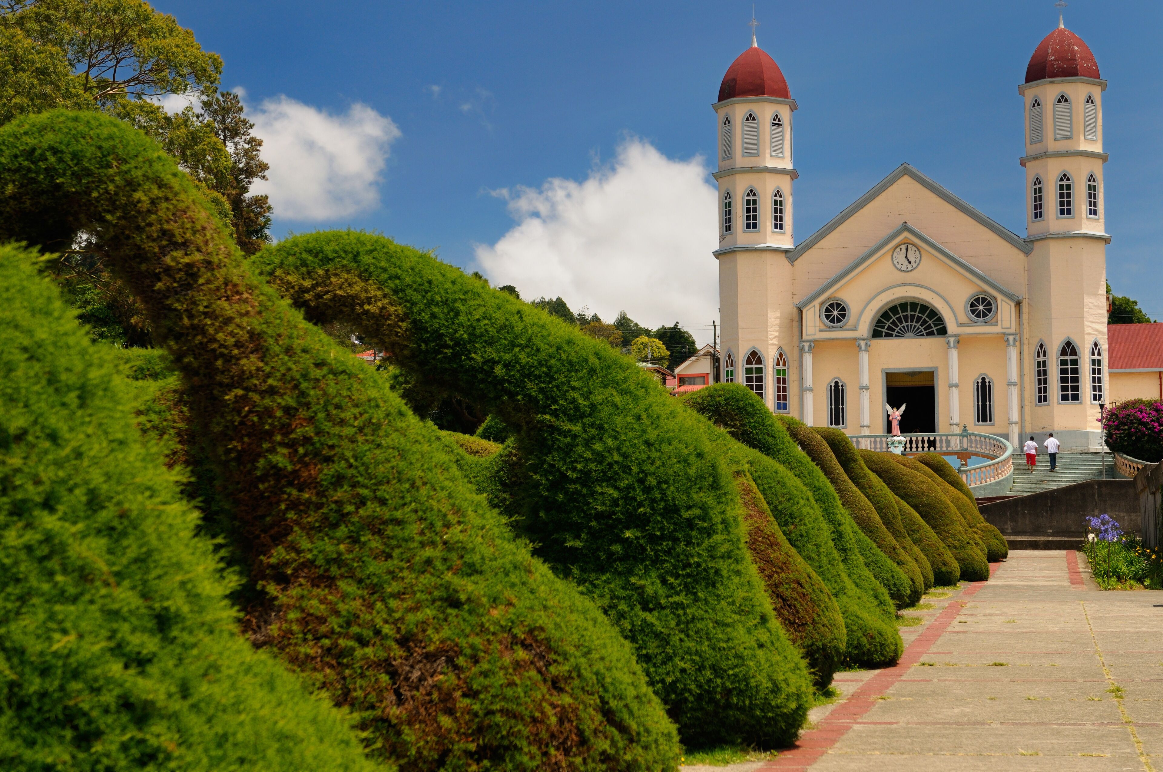 Topiary garden bushes and path in Zarcero Costa Rica leading to stairs and church