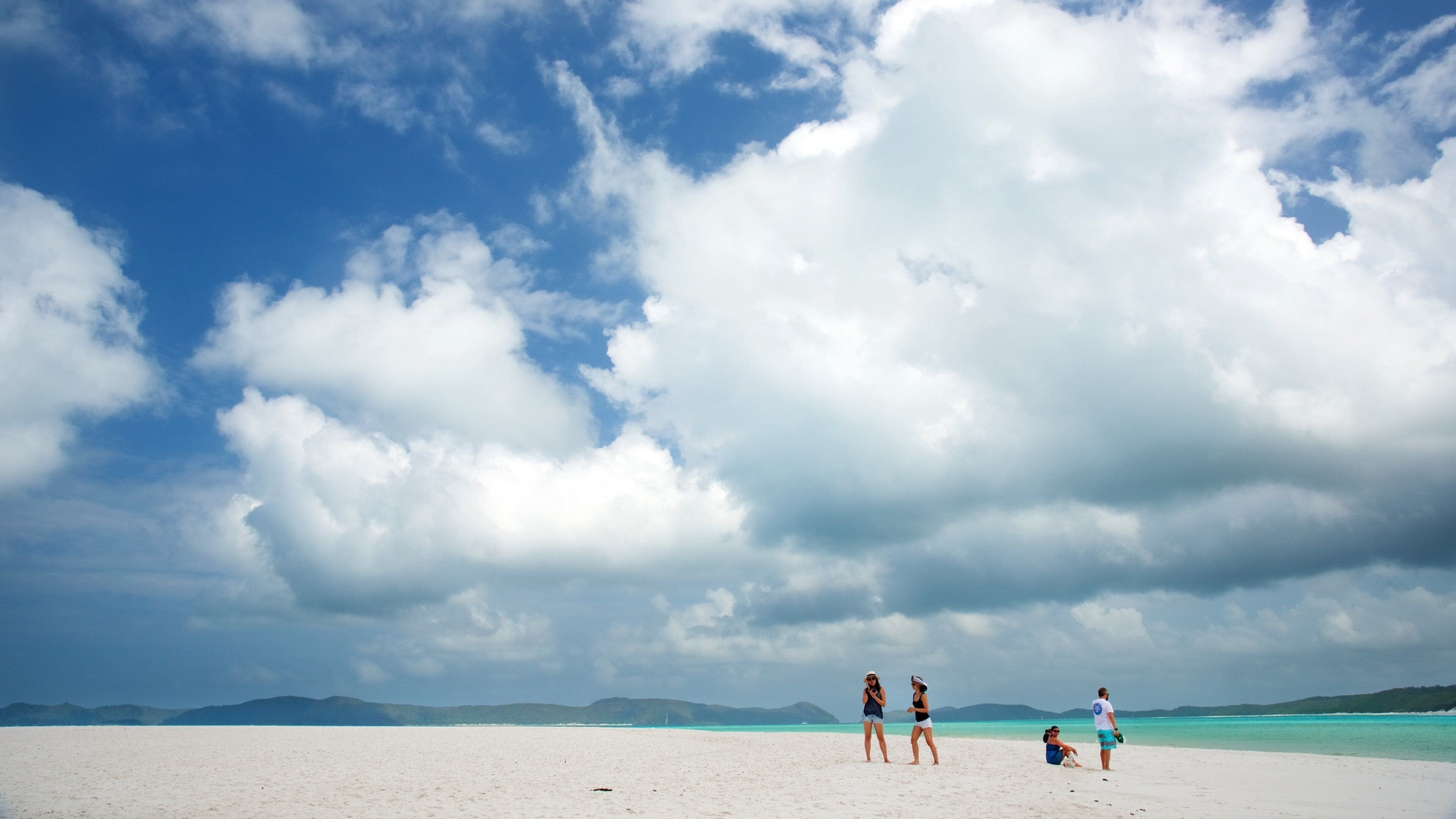 Whitsunday Islands featuring a beach and landscape views as well as a small group of people