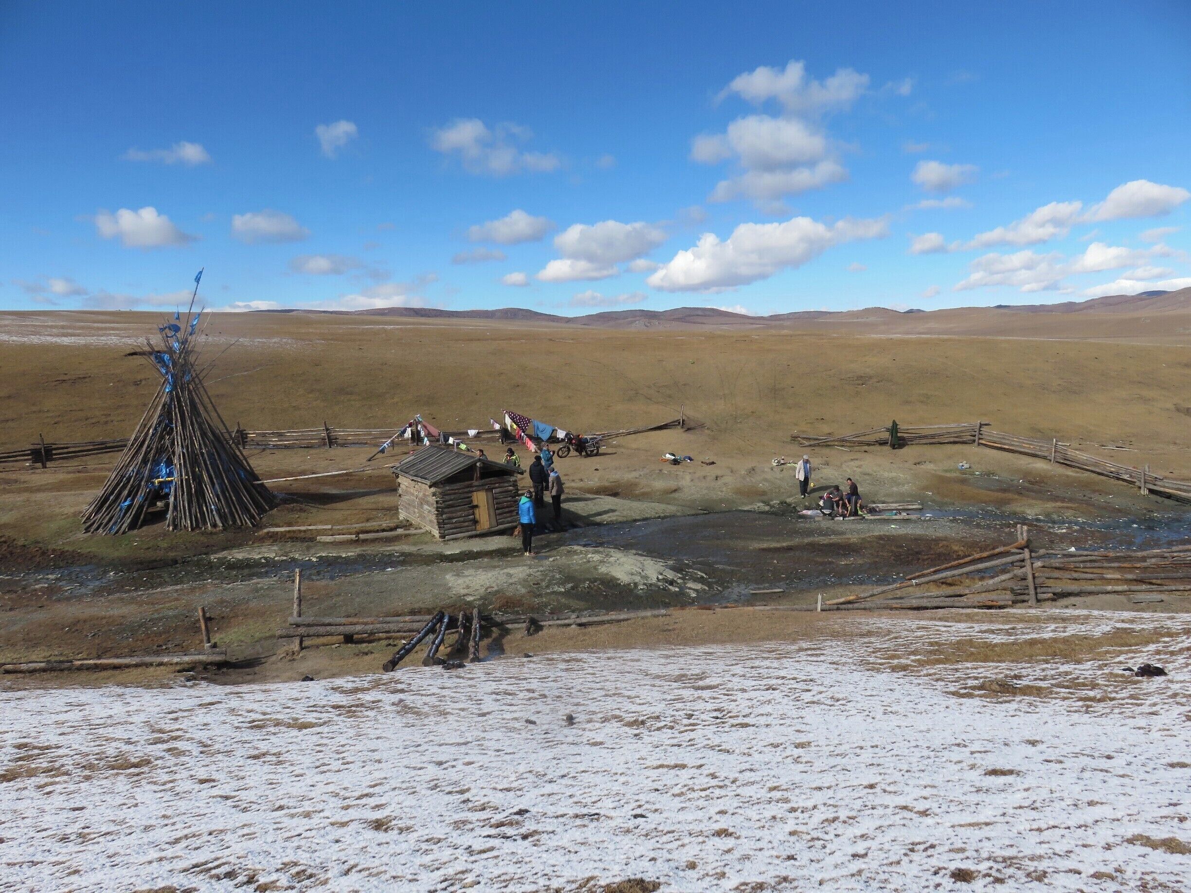 I love this photo because it captures a few things quintessential to the Mongolian landscape. On the left is a Shamanic teepee for honoring the elements and making wishes for good fortune. On the right you see herders washing their clothes in hot springs. There are 63 (or there abouts)  hot springs across the country. The wide steppes go on forever beyond the dusting of early snow. And then there's a sky - a beautiful element for sure!