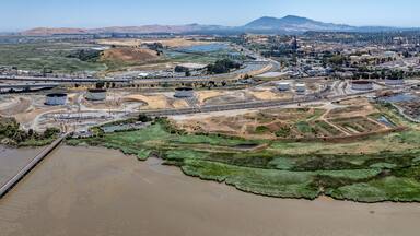panoramic aerial view of shoreline at Carquinez Strait, from Benicia–Martinez Bridge (Interstate 680) across industrial area of Martinez, located in Contra Costa County, California
