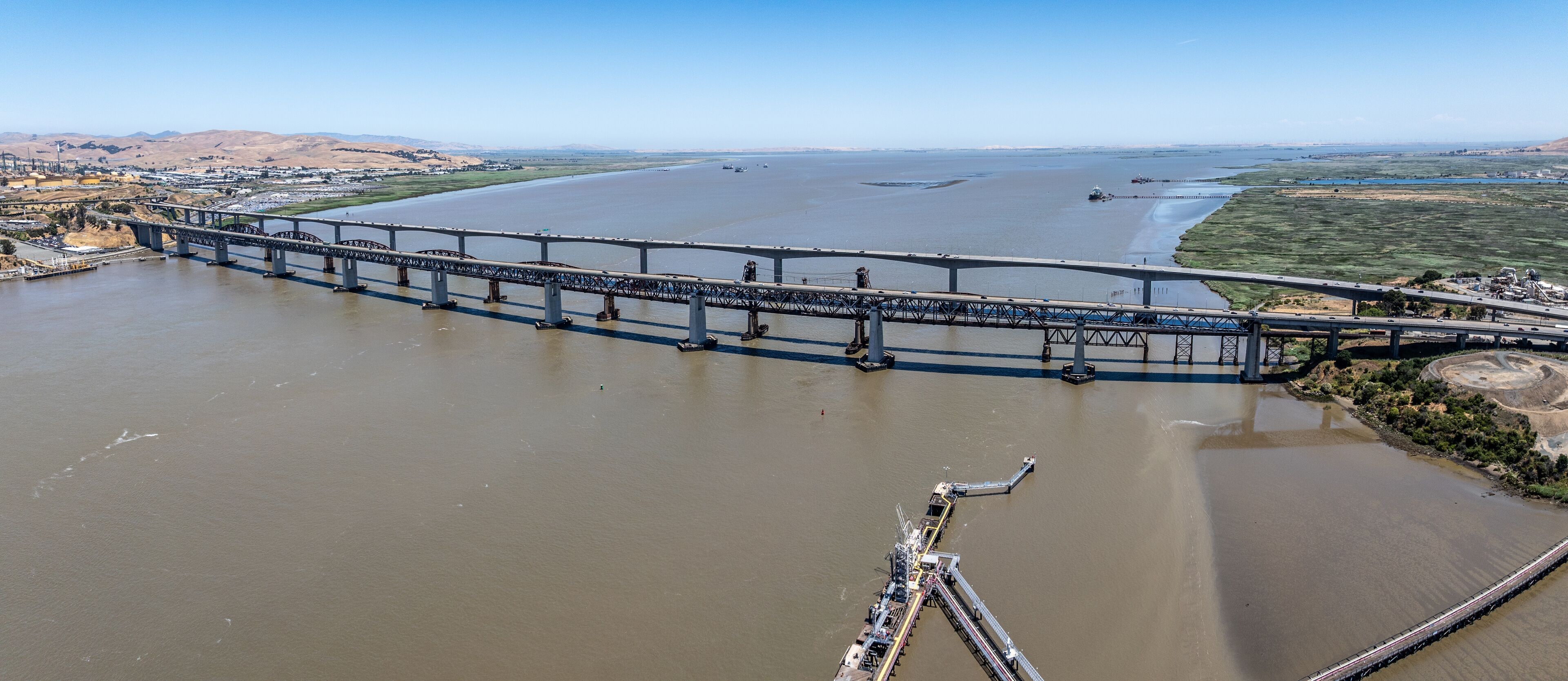 panoramic aerial landscape view of area around Carquinez Strait with Benicia-Martinez Railroad Bridge and Benicia–Martinez Bridge (680) with traffic running in both directions