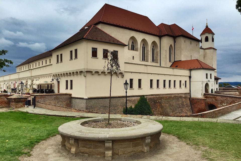 A historic building with a red-tiled roof, arched windows, and a bell tower.