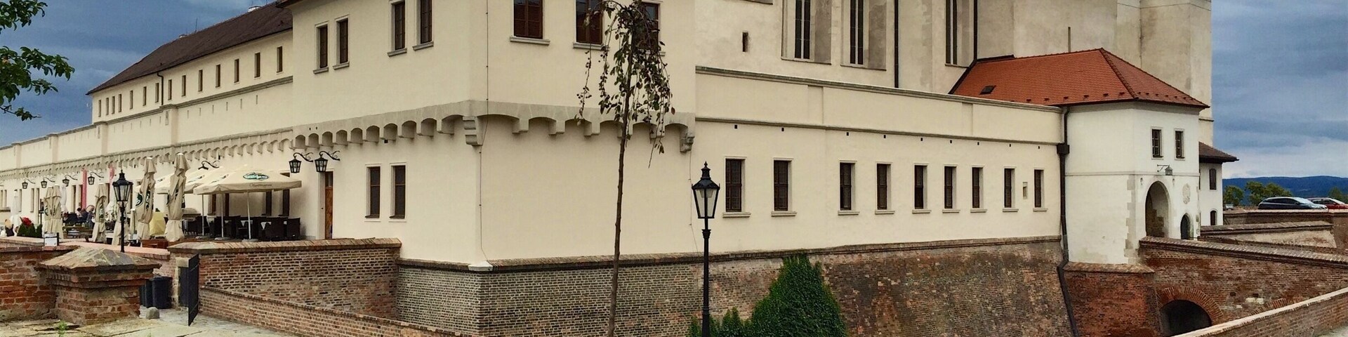 Špilberk Castle is a castle on the hilltop in Brno, Southern Moravia. Its construction began as early as the first half of the 13th century by the Přemyslid kings and complete by King Ottokar II of Bohemia. From a major royal castle established around the mid-13th century, and the seat of the Moravian margraves in the mid-14th century, it was gradually turned into a huge baroque fortress considered the harshest prison in the Austro-Hungarian empire, and then into barracks. This prison had always been part of the Špilberk fortress.