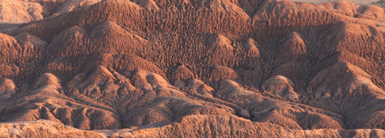 Paisaje desértico con dunas ondulantes y un horizonte lejano.
