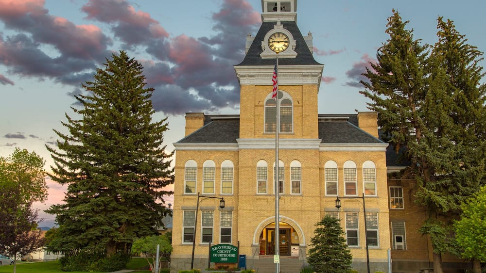 A courthouse with a clock tower, surrounded by trees.