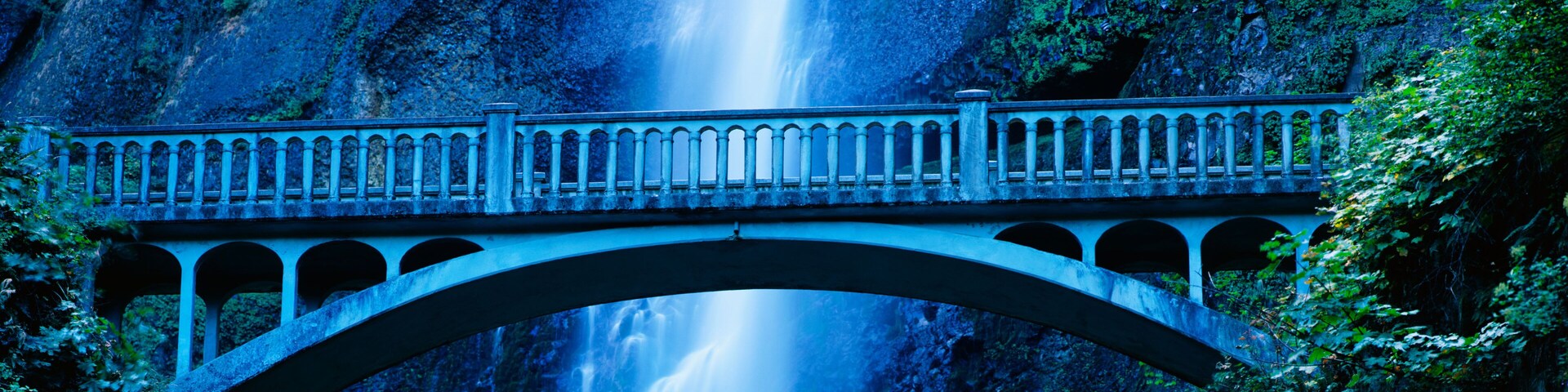 This is a close up of the Multnomah Falls and footbridge. It has a 542 ft. drop from the top.