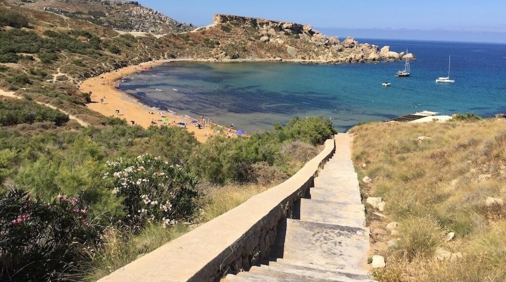 Għajn Tuffieħa Bay is a red beach a short distance south of Golden Bay. It is quieter than Golden Bay and often visited by the Maltese themselves, as well as tourist visitors. In order to reach this beach one needs to descend a hill on a staircase of 200 steps. On top of the cliffs west of Għajn Tuffieħa bay, there is an old defense tower built in 1637. It is one of the seven towers built by Grand Master Giovanni Paolo Lascaris, of the Knights Hospitaller.