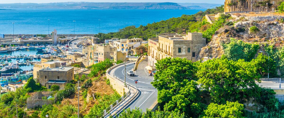 A coastal town with a prominent church, a marina, and a winding road.