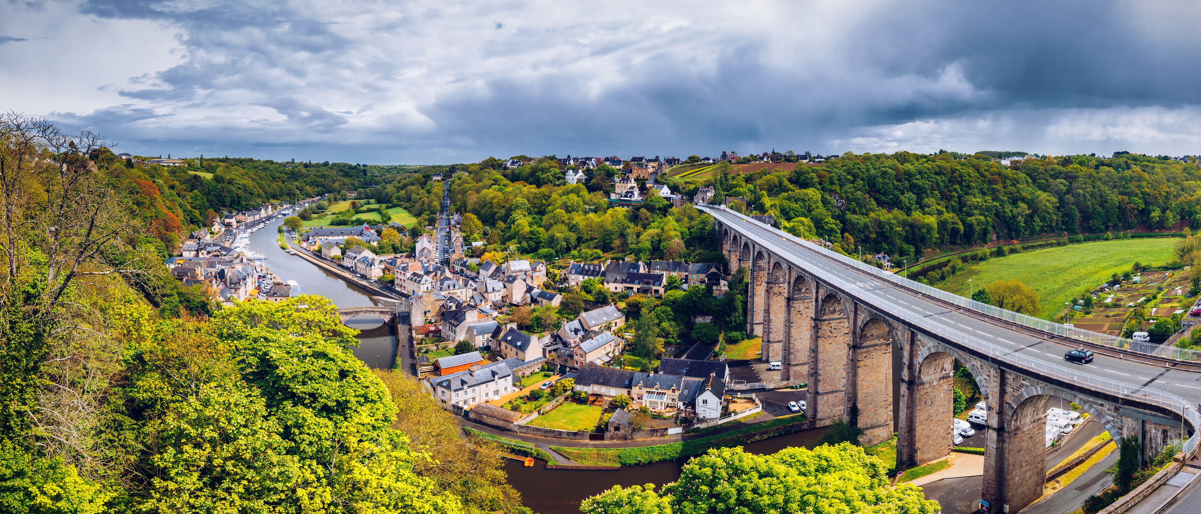 Aerial view of the historic town of Dinan with Rance river with dramatic cloudscape, Cotes-d'Armor department. Brittany (Bretagne), France