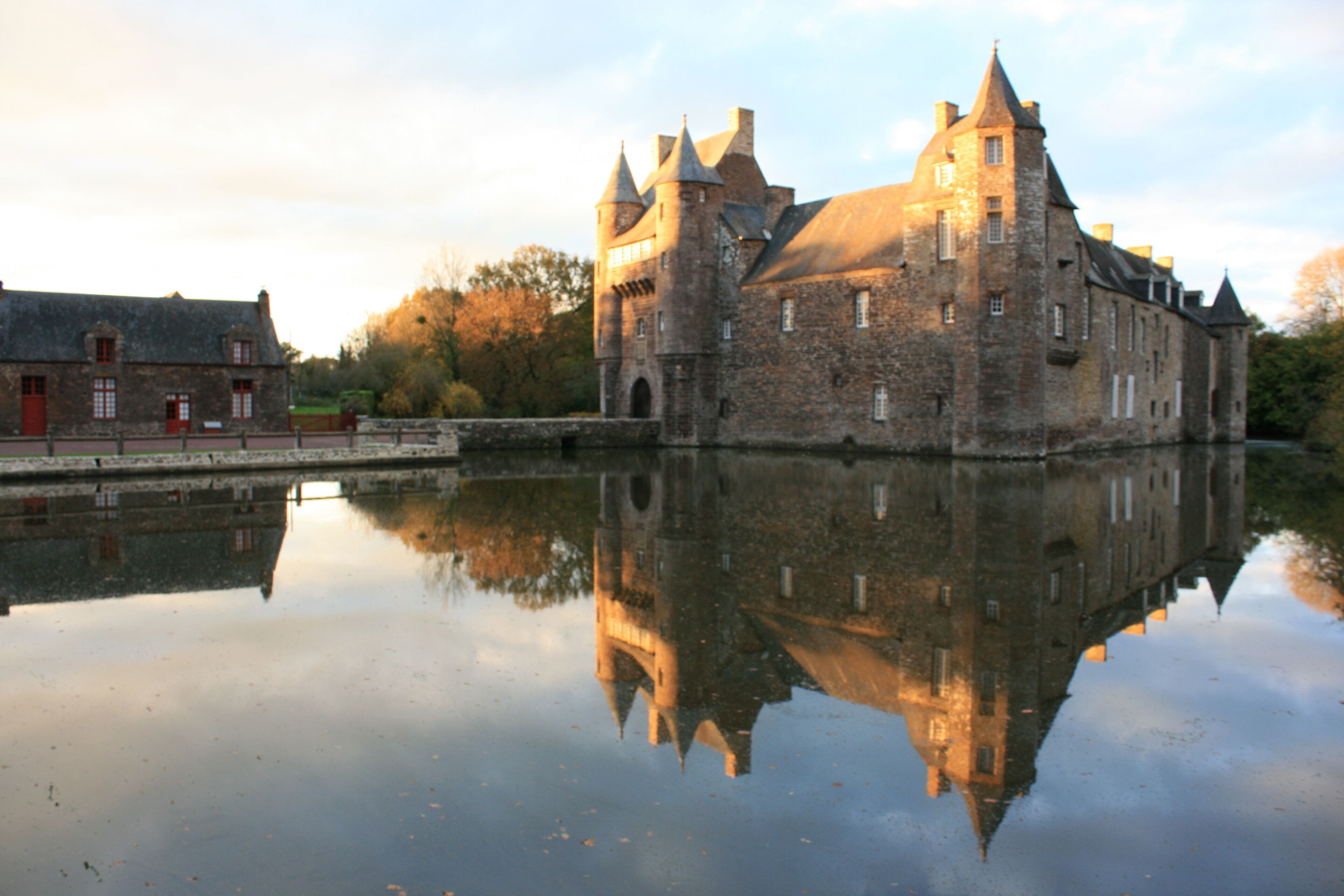 A historic castle with a moat, reflecting its architecture.