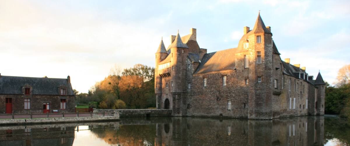 A historic castle with a moat, reflecting its architecture.