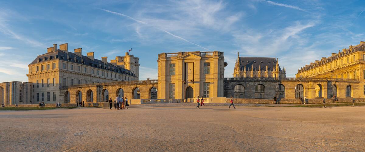 A historic building complex with large arched windows and a central tower.