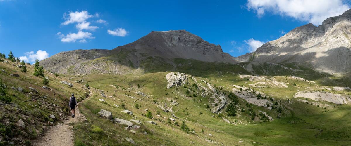 A mountainous landscape with a clear sky, a winding path, and rocky terrain.