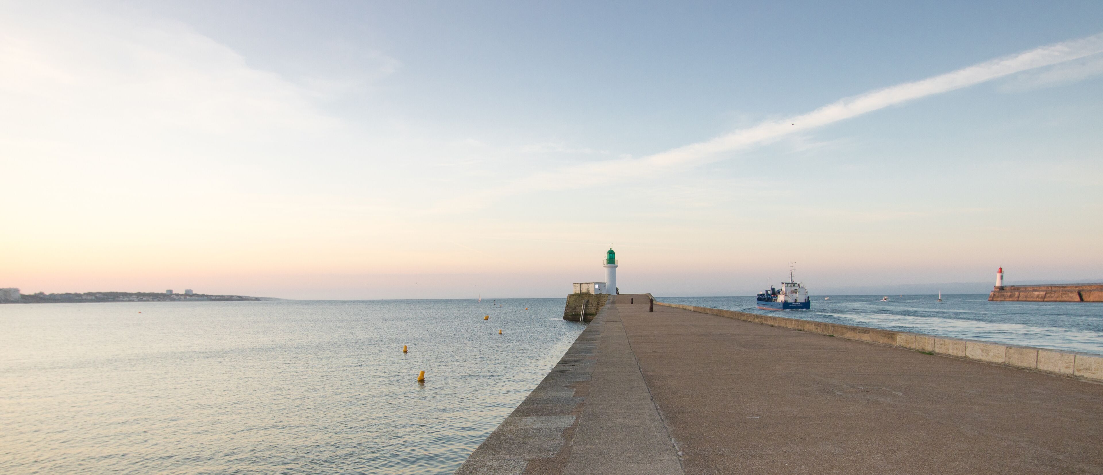 la petite jetée et le phare vert à l'entrée du port des Sables d'Olonne en Vendée en France en été