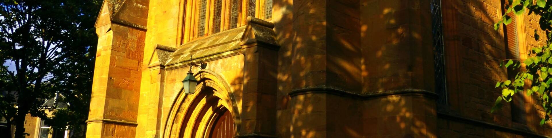A historic church with a large arched window and a clock tower.