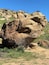 A large rock formation with sparse vegetation.