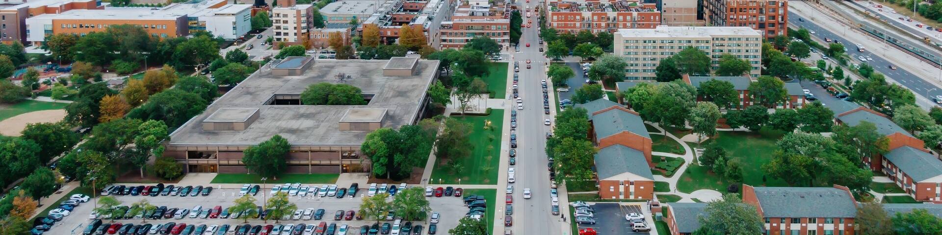 High-angle view of Chicago city streets, buildings, and parking lots. Traffic flows through the urban landscape. West Loop, Chicago, Illinois, United States Of America