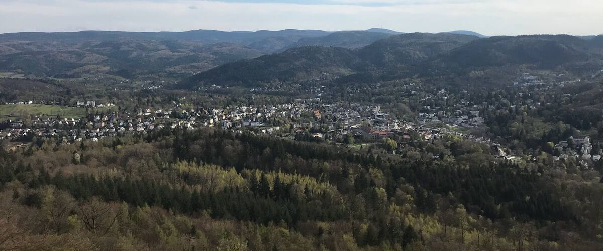 A town nestled in a valley surrounded by forested hills.